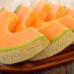 fresh slices of cantaloupes on a wooden plate but can bearded dragons eat cantaloupe?
