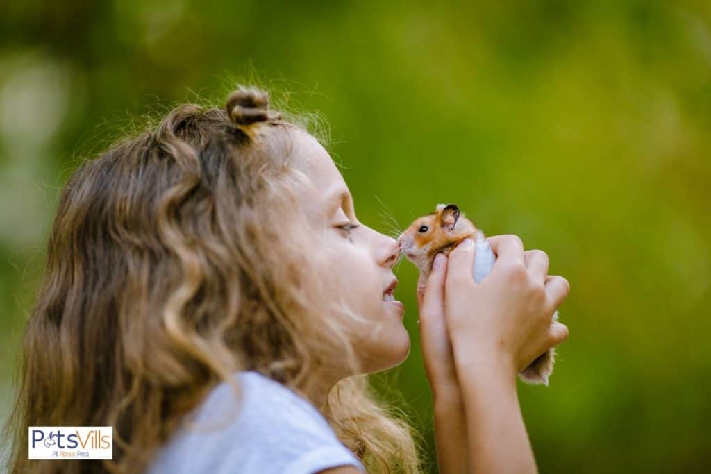 a kid rubbing hamster with her nose