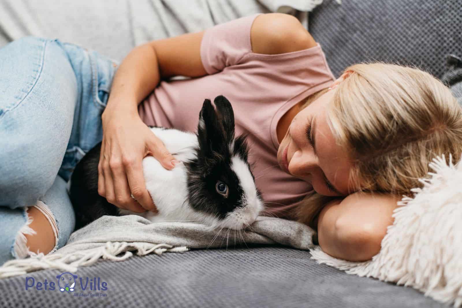 lady cuddling with her rabbit on the bed